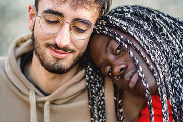 Affectionate biracial couple sitting outdoors - close up shot