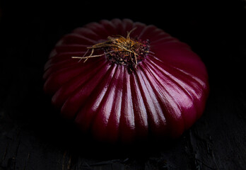 Red onion on black rustic background. Close up. Macro