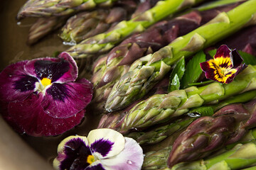 Set of raw white, green, purple asparagus in copper basin with violet and mint. Old wooden rustic background. Organic healthy eating concept. Close up. Overhead.