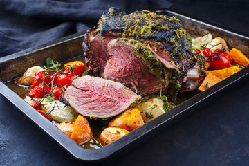 Traditional English barbecue lamb roast with mint leaf and vegetable served as close-up in a rustic tray © HLPhoto
