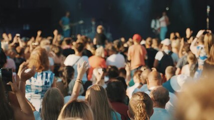 People enjoying musical concert on large stage.