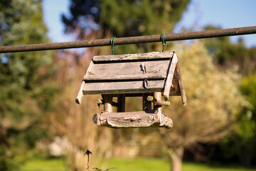 Ein hölzernes Vogelhaus an einer Metallstange befestigt.
