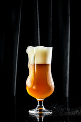 Beer. Cold Craft light Beer in a glass with water drops. Pint of Beer into a tall glass with a thick foam