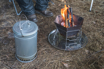 冬のキャンプで煙の出る燻製器と焚火