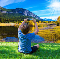 Boy in T-shirt photographs the landscape