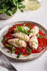 traditional Italian food culurgiones with tomato sauce and basil