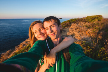 Young Couple Taking Selfie by Sea at Sunrise