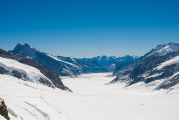 Fototapeta na wymiar A breathtaking view of the valley and swiss mountains from Jungfrau, the top of Europe with deep blue sky