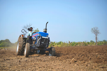 Obraz premium Indian farmer working with tractor in agriculture field.