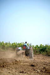 Indian farmer working with tractor in agriculture field.