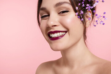 Happy  pretty girl with perfect make up, glowing healthy skin, bare shoulders, lilac flowers in...