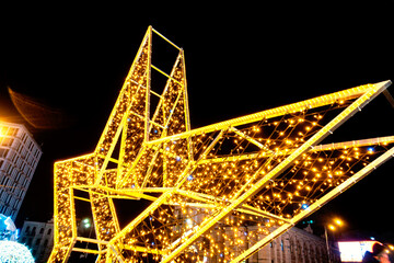 Glowing pointed yellow star hung with garlands