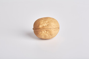 One whole walnut lies on a light background in the center