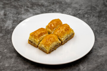 Walnut baklava on a dark background. Traditional Turkish cuisine delicacies. Close-up.