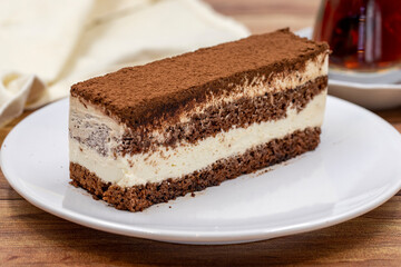 portion tiramisu cake on wooden background. Traditional world cuisine delicacies. Close-up.