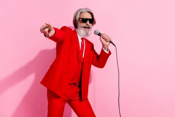 Fototapete Porträt eines attraktiven, trendigen, fröhlichen, grauhaarigen Mannes, mc Showman, der singt, wählen Sie isoliert auf rosafarbenem, pastellfarbenem Hintergrund © deagreez