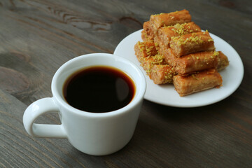 Closeup a Cup of Turkish Coffee with Blurry Plate of Baklava Pastries in the Backdrop