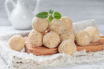 Close-up view of healthy raw paleo energy coconut balls on wood board. Soft focus.