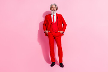 Photo of attractive charming retired man wear red suit walking arms pockets isolated pink color background