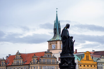 Naklejka premium View of the statue on the famous Charles bridge and historical center of Prague, buildings and landmarks of old town at sunset, Prague, Czech Republic.