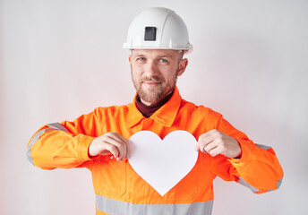 Portrait of bearded construction site worker or supervisor male standing by the wall in helmet and...
