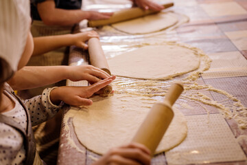 Children hands and flour, making dough for pizza and pies.