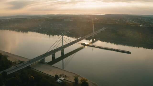 Most slobode, Novi Sad. Liberty Bridge at dawn, freight ship paising under the bridge,  Novi Sad, Serbia.