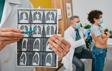 Auscultation of lungs and respiratory system. Pediatrician listening to boy's lungs using a stethoscope. Pulmonologist showing CT scan of lungs in foreground