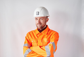 Smiling young construction worker or technician in hard hat. Bearded male supervisor or construction architect in white hard hat and safety orange reflective vest. High quality photo