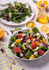 Healthy orange, avocado, grapefruit and pomegranate salad with honey and mustard dressing.