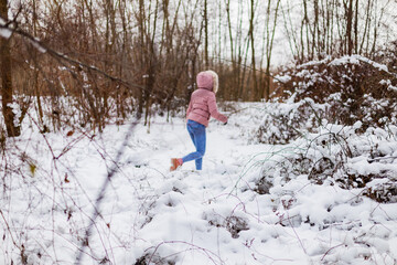 child walking in winter forest