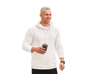 Men holding coffee in hand standing isolated white background studio shoot. Caucasian handsome male dressed white hoodie looking away positive emotions teeth smiling.