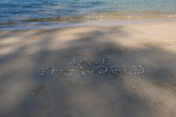 The shell is arranged as a message of protecting the world on the sandy beach.