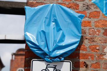 Mit blauer Plastikfolie verhülltes Verkehrsschild, Deutschland