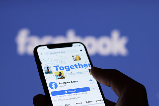 Chiang Mai, Thailand, January 9, 2022 : Facebook fan page on the smartphone screen and facebook logo background