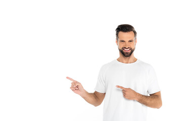 happy man in t-shirt pointing with fingers while looking at camera isolated on white.
