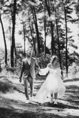 Fototapeta na wymiar Groom and bride on their wedding day in forest