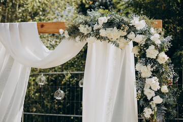 Wedding arch decorated with flowers and fabric outside