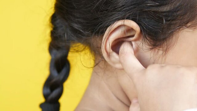  child girl having ear pain touching his painful ear ,
