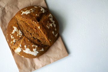 Whole-grain rye bread with sourdough. Round embossed bread on a white background.