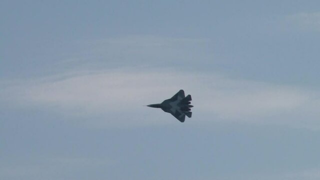 Fifth-generation multi-purpose aircraft Su-57 performs aerobatics against blue sky with white clouds. Zhukovsky, Russia, August 18, 2011. 
