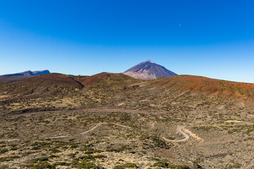 Teide mountain with moon, blue sky and street