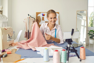 Smiling woman designer or seamstress talk on webcam call on cellphone have online consultation....