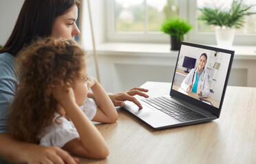 Fototapeta Healthy mother and child enjoying digital era, having online telemedicine consultation with remote doctor or watching educational video by professional paediatrician about cold and flu virus treatment obraz