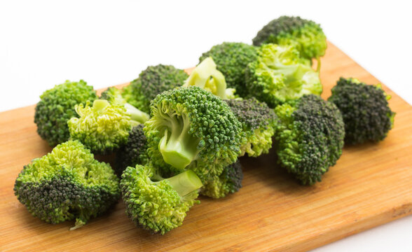 healthy broccoli and florets on wooden board