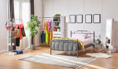 Metal bedstead in the bed room, white wall background, frame, wardrobe, clothes and blanket style.