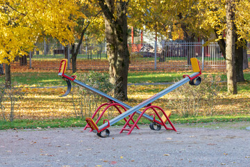 Empty seesaw on playground in public park. Wooden seesaw in the park. Colorful children playground.