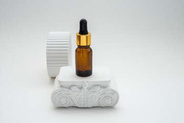 Cosmetic jar of facial essence stands on the podium. Cosmetics on a white background. Mockup Body oil bottle