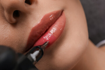 Young woman undergoing procedure of permanent lip makeup in tattoo salon, top view - obrazy, fototapety, plakaty