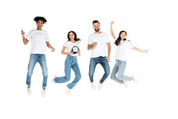 full length view of multiethnic friends with headphones and mobile phones levitating isolated on white.